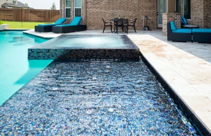 backyard pool with tile tanning shelf in Kingwood, TX