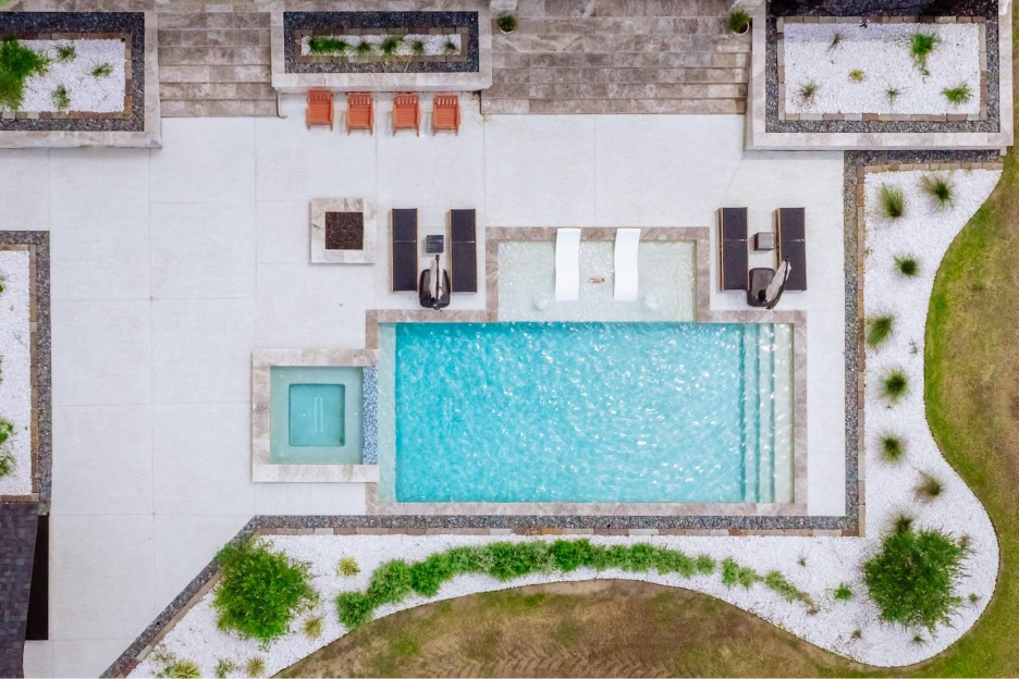 drone shot of pool with spa and tanning shelf